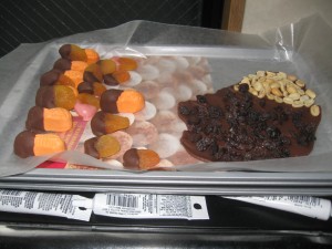 Chocolate dipped fruit and candy on a tray.